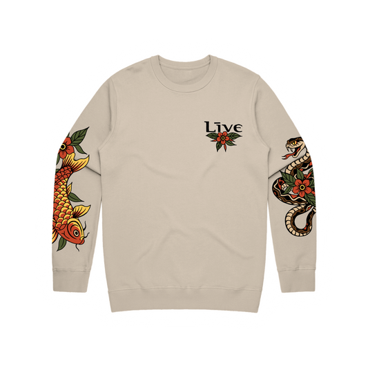 Beige sweatshirt with sleeve designs of a fish, flowers, and a snake, featuring the word 'Live' inspired by illustrative tattoos